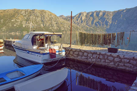 Fishing boats in small harbour on sunny autumn day. Beautiful Mediterranean landscape. Montenegro, Adriatic Sea. View of Bay of Kotor near Prcanj townの写真素材