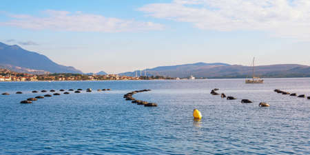 Mussel farm. Cultivation of mussels, rope culture. Beautiful Mediterranean landscape. Montenegro, Adriatic Sea. View of Bay of Kotor, city of Tivat in distanceの写真素材