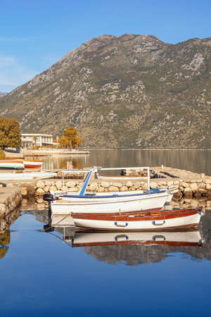 Beautiful autumn Mediterranean landscape. Fishing boats in small harbour. Montenegro, Adriatic Sea. View of Kotor Bay near Prcanj town (Kotor )の写真素材