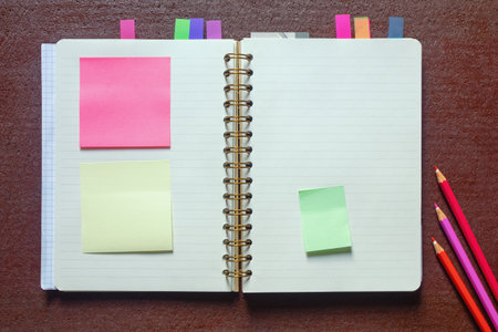 Open spiral bound notebook with  blank pages and post-it notes. Flat lay, copy spaceの写真素材