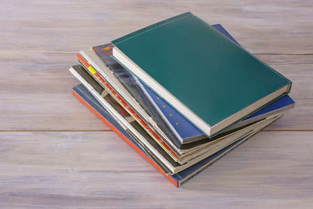 Stack of different books and magazines on rustic tableの写真素材