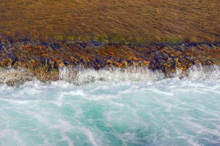 Abstract natural background. Contrasts of color and texture. Flowing water and threshold on river,...