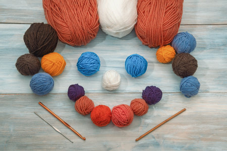 Hobby and knitting concept. Gnome of knitting. Colorful skeins and balls  of wool on rustic table. Space for textの写真素材
