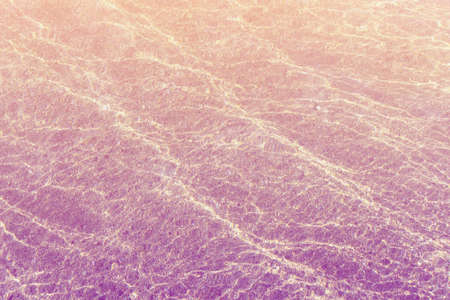 Natural water background. Texture of shallow water at sunset.  Toned imageの写真素材