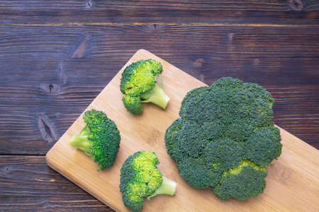 Green vegetables. Broccoli on cutting board. Dark rustic table, copy spaceの写真素材