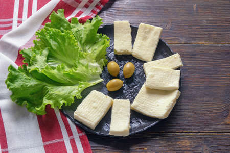 Balkan cuisine. Montenegro. Pljevaljski cheese  - local soft white cheese. Dark rustic table, copy spaceの写真素材
