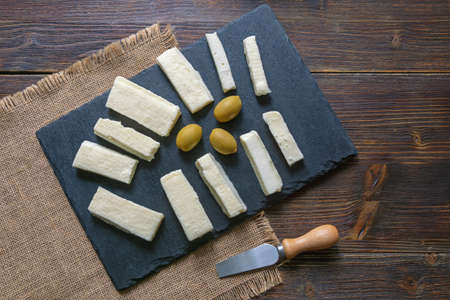 Balkan cuisine. Montenegro. Pljevaljski cheese  - local soft white cheese on dark rustic table. Copy...
