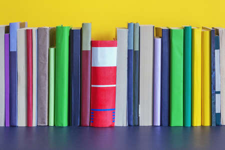Different colorful books on bookshelf. Free space for textの写真素材