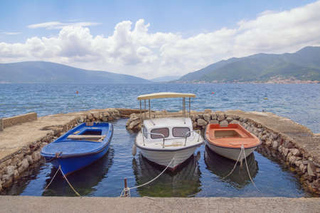 Beautiful Mediterranean landscape. Fishing boats at small stone jetty. Montenegro, Adriatic Sea. View of Bay of Kotor, Tivatの写真素材