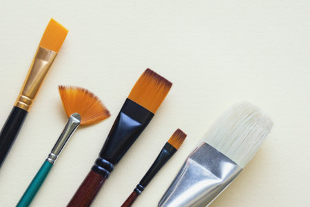 Different artistic paint brushes on paper background. Copy spaceの写真素材