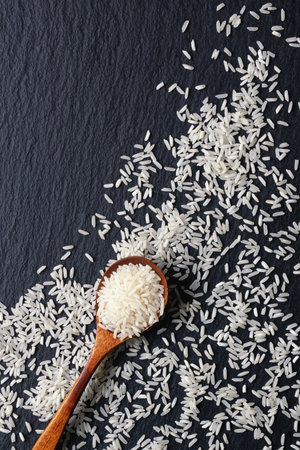Long grain rice on black table. Copy spaceの写真素材