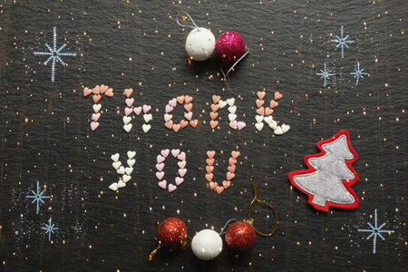 Word Thank you from small colorful hearts. Christmas and New Year decorations. Light garland, double expositionの写真素材