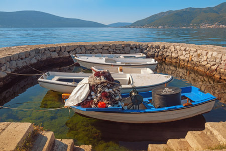 Montenegro, Adriatic Sea, view of Bay of Kotor near Tivat city. Fishing boats at small stone jettyの写真素材