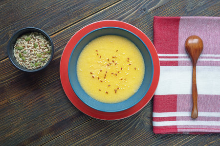 Breakfast. Cornmeal porridge and different seeds in  bowls on rustic table . Flat lay, copy spaceの写真素材