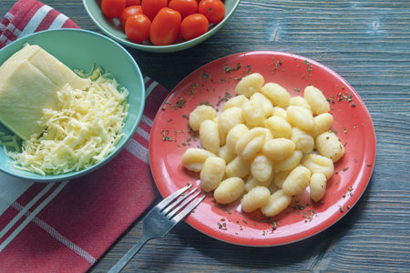Balkan cuisine. Njoke ( potato gnocchi, dumpling ), cheese and cherry tomatoes . Copy spaceの写真素材