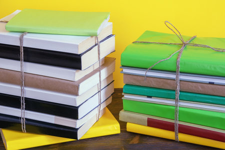 Two stacks of different books tied with rope on rustic tableの写真素材