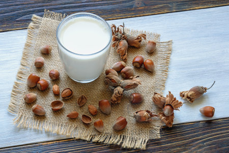 Nut milks. Glass of dairy-free hazelnut milk on rustic tableの写真素材