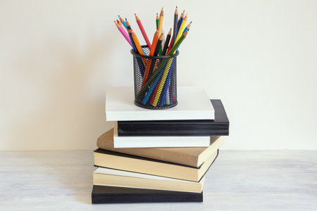 Pencil holder with pencils and stack of books. Copy spaceの写真素材