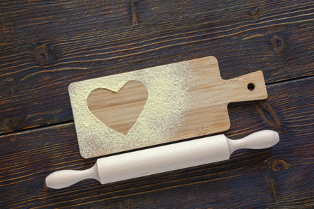 Cutting board with flour and rolling pin for dough on rustic table. Flat lay, copy spaceの写真素材