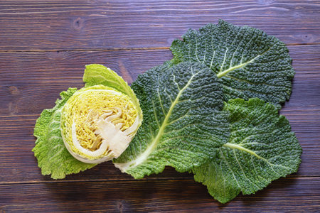 Leaves and half a head of  Savoy cabbage on dark rustic table. Copy spaceの写真素材