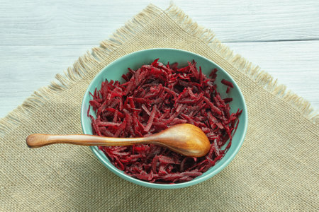 Grated red beetroot in bowl on rustic table. Copy spaceの写真素材