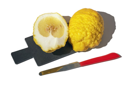 Yellow Citron ( Citrus medica, cedrate ) on cutting board isolated on whiteの写真素材