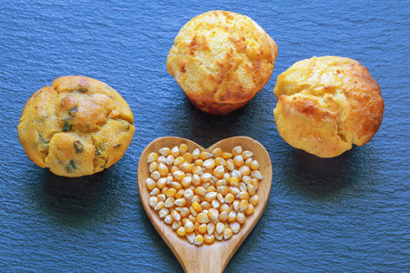 Balkan cuisine, proja -  cornbread, prepared as muffins. Corn kernels in heart shaped wooden spoon