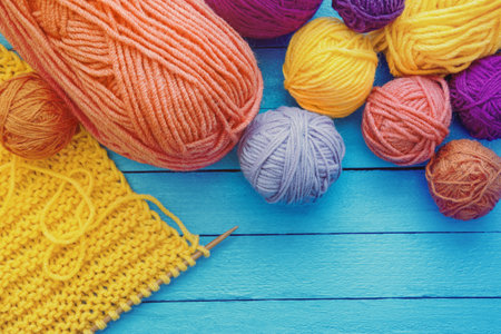 Hobbies and knitting concept. Colorful balls of wool on blue rustic table. Copy spaceの写真素材