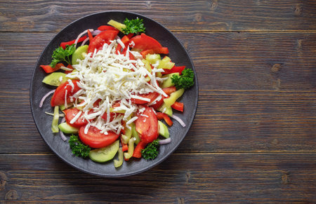Balkan cuisine. Shopska Salad, traditional dish of the Balkan. It is made from vegetables and cheese. Dark rustic table. Copy spaceの写真素材