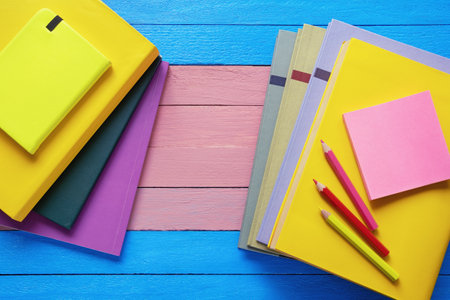 Bright books and colored pencils on rustic table. Flat lay. Copy spaceの写真素材