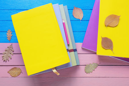 Bright books and autumn leaves on rustic table. Flat lay. Copy spaceの写真素材