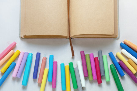 Sketchbook and colorful pastel crayons on textured paper. Copy spaceの写真素材