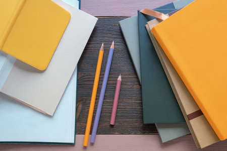 Different books and colored pencils on  table. Free spaceの写真素材