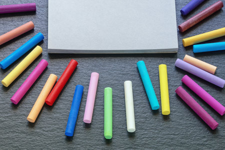 Sketchbook and colorful pastel crayons on dark table. Copy spaceの写真素材