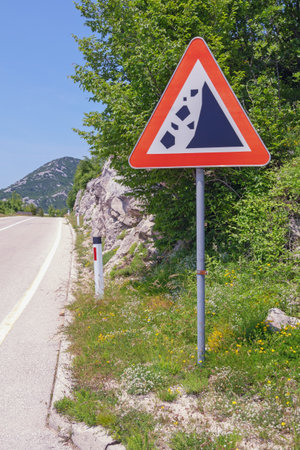 Road with a warning road sign of falling stones. Montenegro, Dinaric Alpsの写真素材