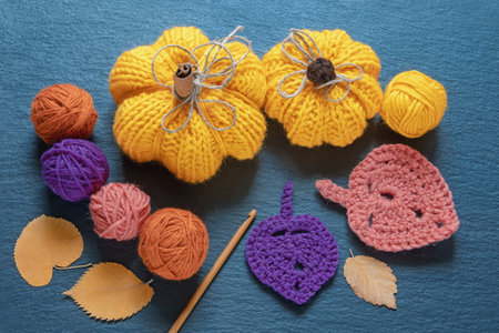 Knitting and hobby concepts. Knitted pumpkins, balls of wool and autumn leavesの写真素材