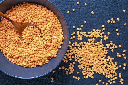 Legumes. Dry red lentils in plate on dark tableの写真素材