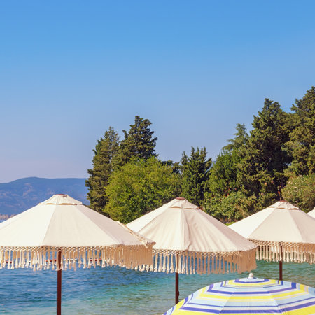 Summer beach vacation, sun umbrellas on coast of bay. Montenegro, Bay of Kotorの写真素材