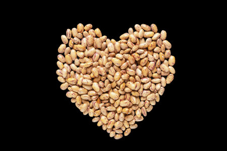 Heart shaped brown beans on black. Flat lay, copy spaceの写真素材