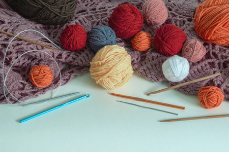 Knitting and hobby concept. Colorful balls of wool, knitted scarf,  knitting  needles and Ñrochet hooks on rustic tableの写真素材