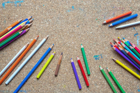 Different colored pencils on old cork board. Copy spaceの写真素材