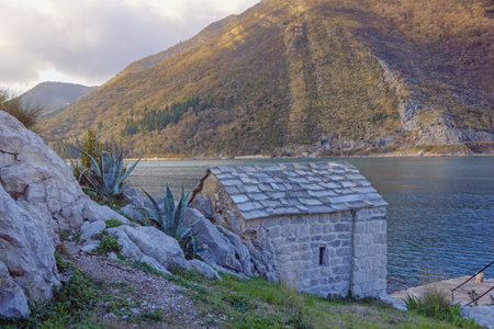 Winter Mediterranean landscape. Coast of Kotor Bay and ancient Church of Our Lady of the Snow on cloudy day. Montenegroの写真素材