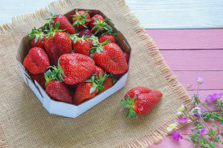 Strawberries from market. Fresh ripe fruit in cardboard box on rustic table. Copy spaceの写真素材