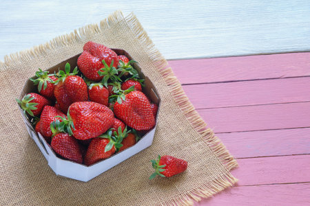 Strawberries from market. Fresh ripe fruit in cardboard box on rustic table. Copy spaceの写真素材