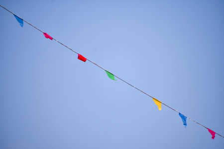 Colorful pennant flag with blue sky background. Festive decoration, celebration. Copy space. For background use.の写真素材