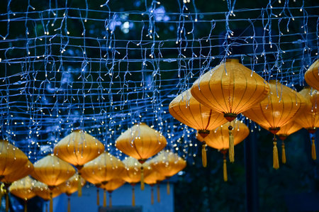 Close-up of the traditional Chinese lantern with outdoor starry solar string lights. Orange lantern. Festive decoration. Mid-autumn festival, Chinese New Year decoration for celebrの写真素材