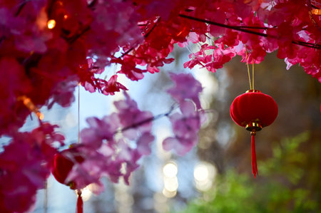 Close-up of the Chinese traditional red lantern decor with artificial peach blossom flower in outdoors. Festive decoration and celebration. Chinese New Year decoration.の写真素材