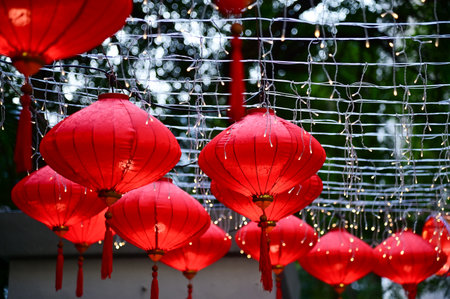 Close-up of the traditional Chinese red lantern with outdoor starry solar string lights. Big red lantern. Festive decoration. Mid-autumn festival, Chinese New Year decoration for cの写真素材