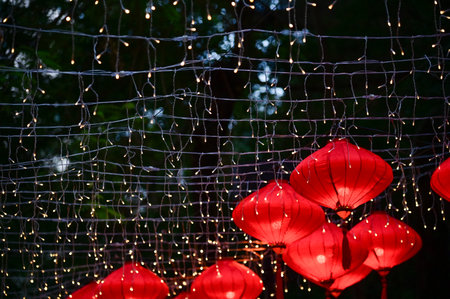 Close-up of the traditional Chinese red lantern with outdoor starry solar string lights. Big red lantern. Festive decoration. Mid-autumn festival, Chinese New Year decoration for cの写真素材