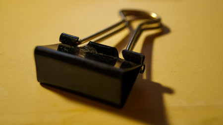 Close-up of a binder clip on the table. Stationary. For holding paper, holding materials. Filing.の写真素材